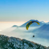 Paraglider navigating a mountain ridge, like a CFO skillfully navigating change management.
