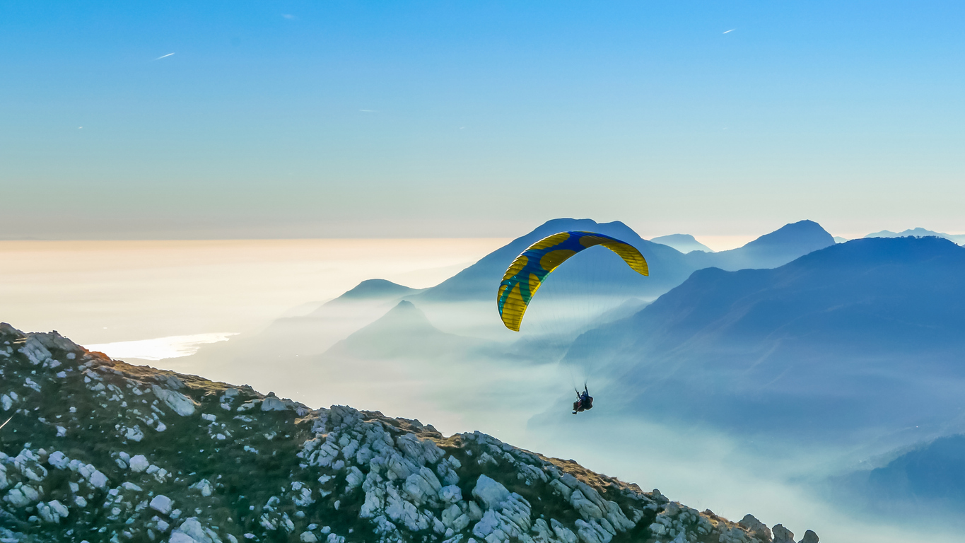 Paraglider navigating a mountain ridge, like a CFO skillfully navigating change management.
